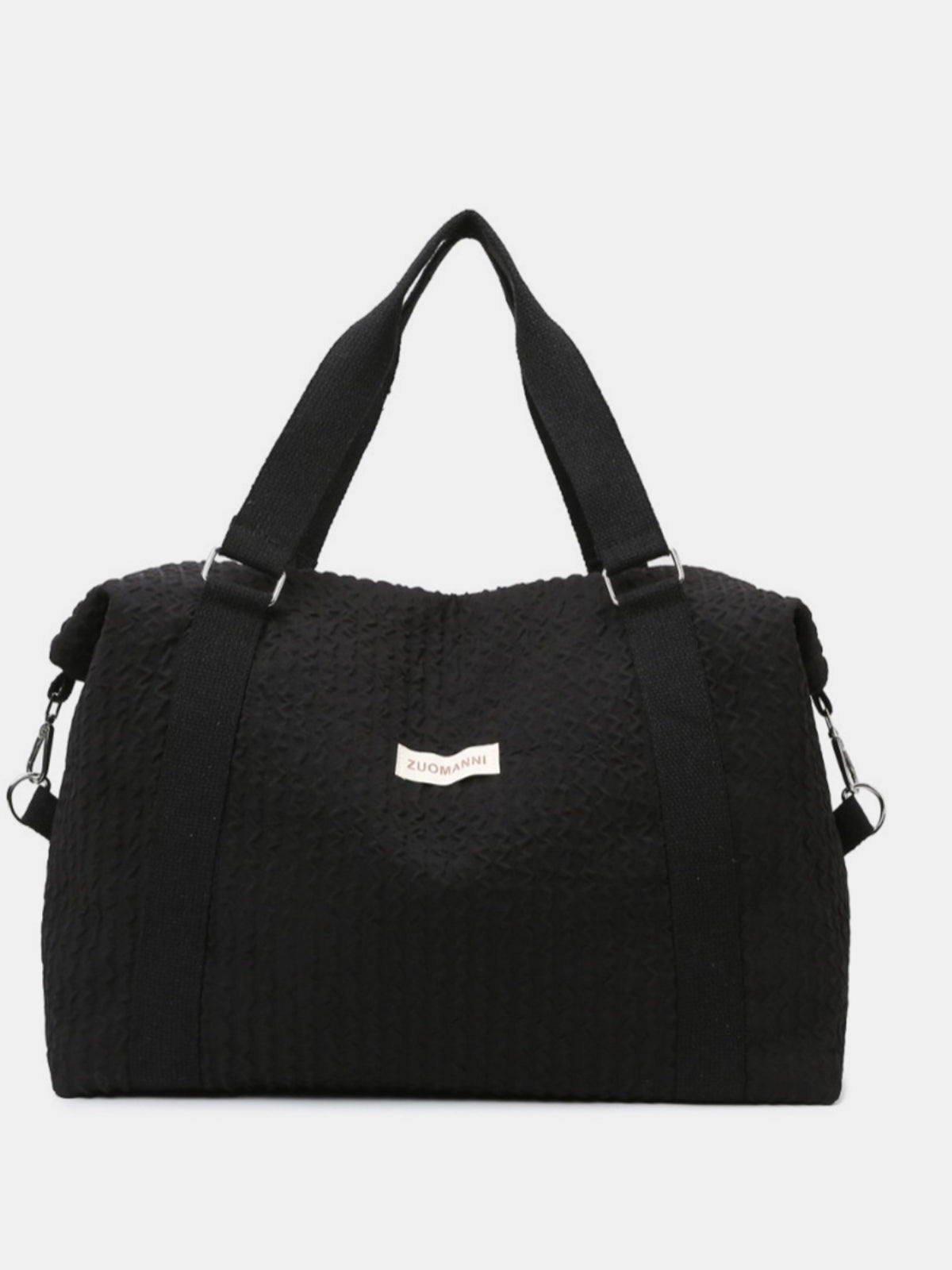 Large black textured Oxford cloth travel bag with a softly structured silhouette, wide top handles, reinforced straps, and a detachable shoulder strap.