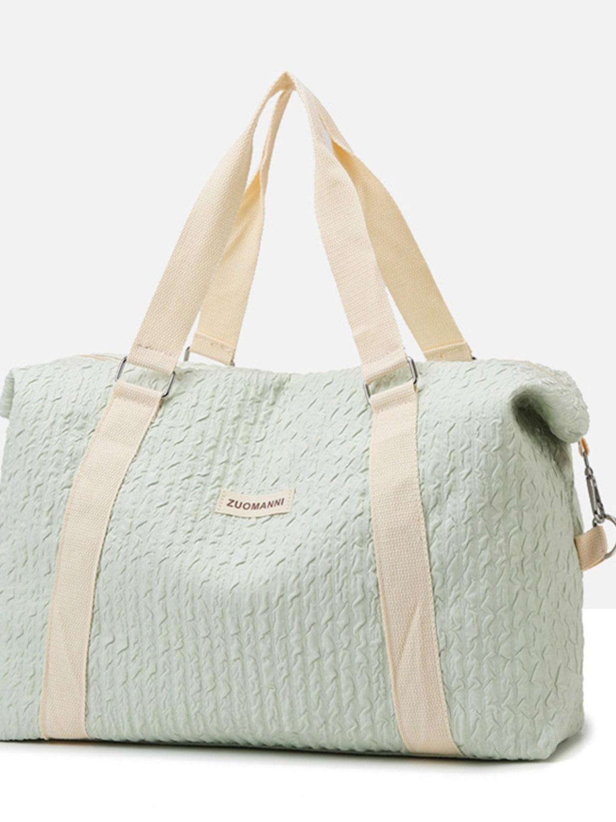 Large mint-green textured Oxford cloth travel bag with a softly structured silhouette, wide beige top handles, and a detachable shoulder strap.