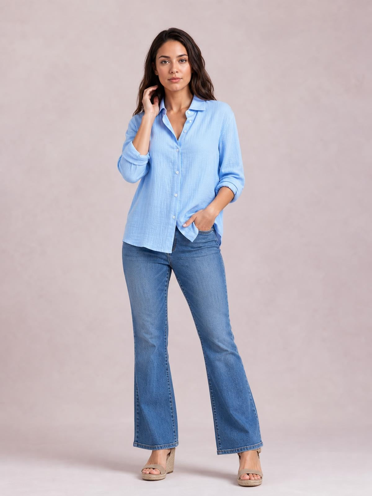 Model poses in a light blue textured button-front shirt with a collared neckline, long rolled sleeves, regular fit, and curved hem.