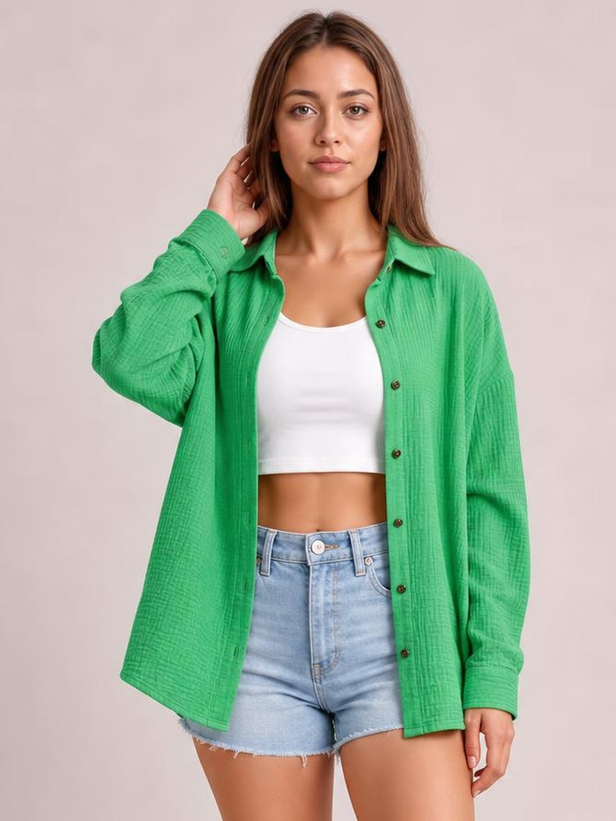 A model poses in a green textured dropped-shoulder longline shirt with a collared neckline, button front, and relaxed long sleeves.