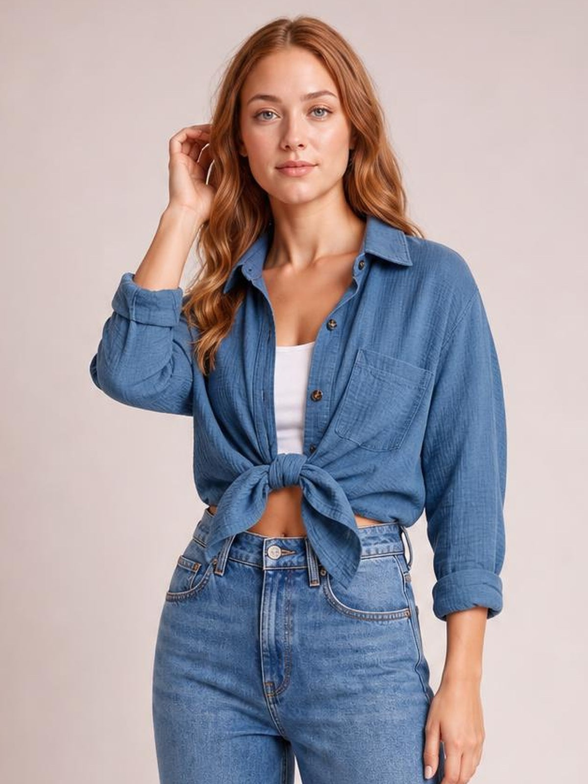 Model wears a textured blue longline shirt with a collared neck, dropped shoulders, rolled long sleeves, button front, and chest pocket, tied at the waist.