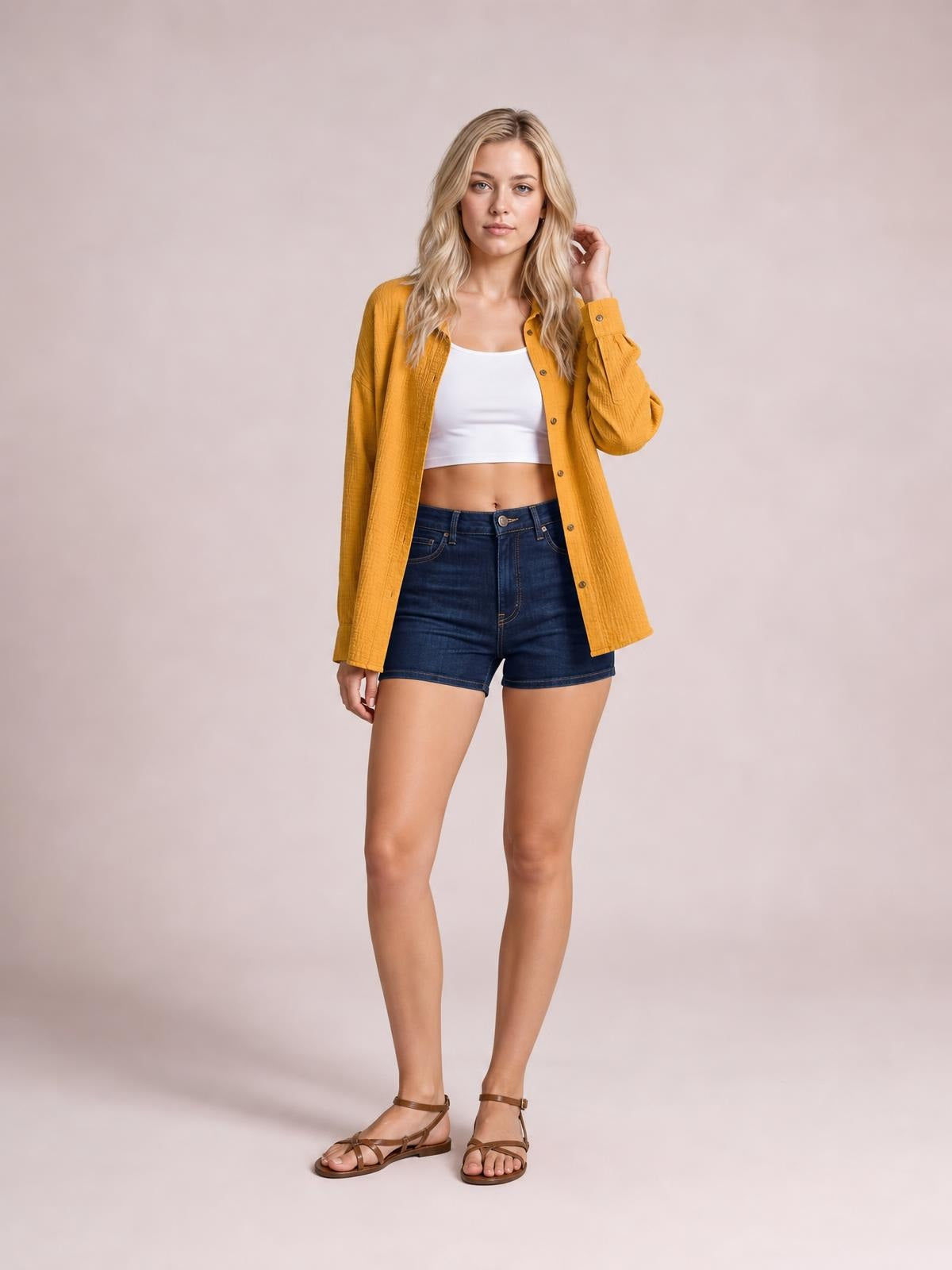 A model poses in a solid mustard-yellow textured longline shirt with a collared button front, dropped shoulders, long sleeves, and pockets.
