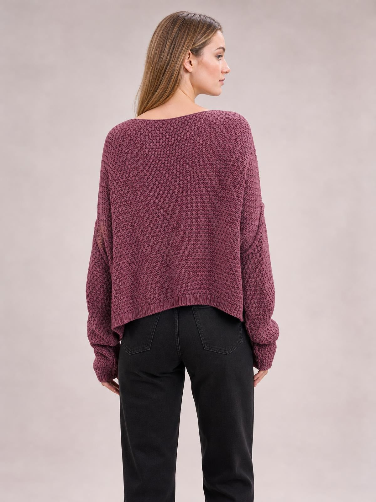 Model shown from behind wearing a plum textured knit round-neck sweater with a relaxed cropped silhouette, dropped shoulders, ribbed cuffs, and hem.