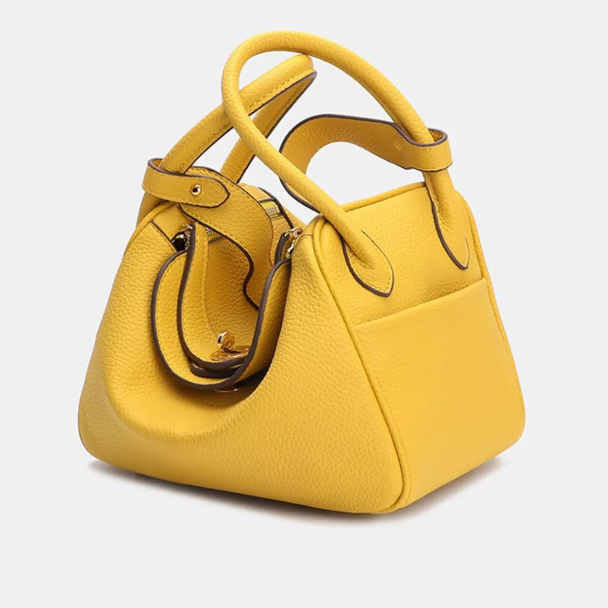 Small yellow textured PU leather handbag with a structured trapezoid silhouette, double top handles, dark contrast piping, and a front slip pocket.