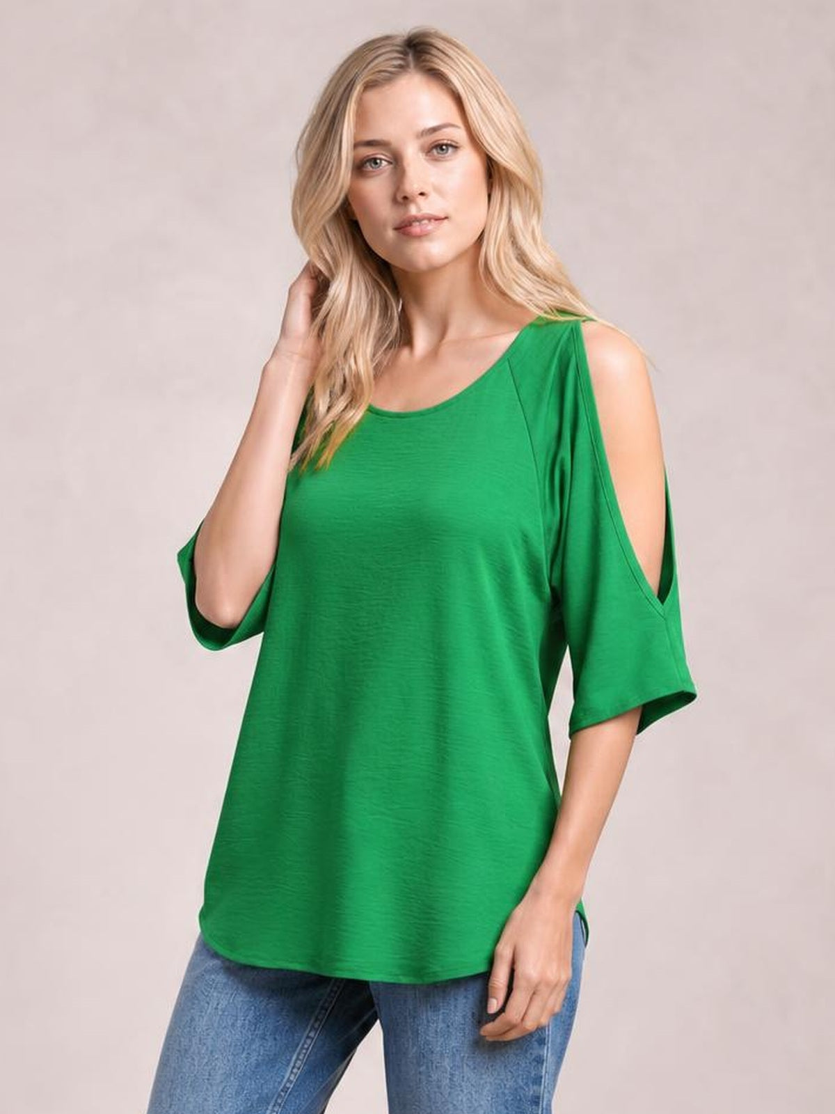 Model poses in a bright green textured round-neck top with cold-shoulder split sleeves, a relaxed long silhouette, and curved hem.