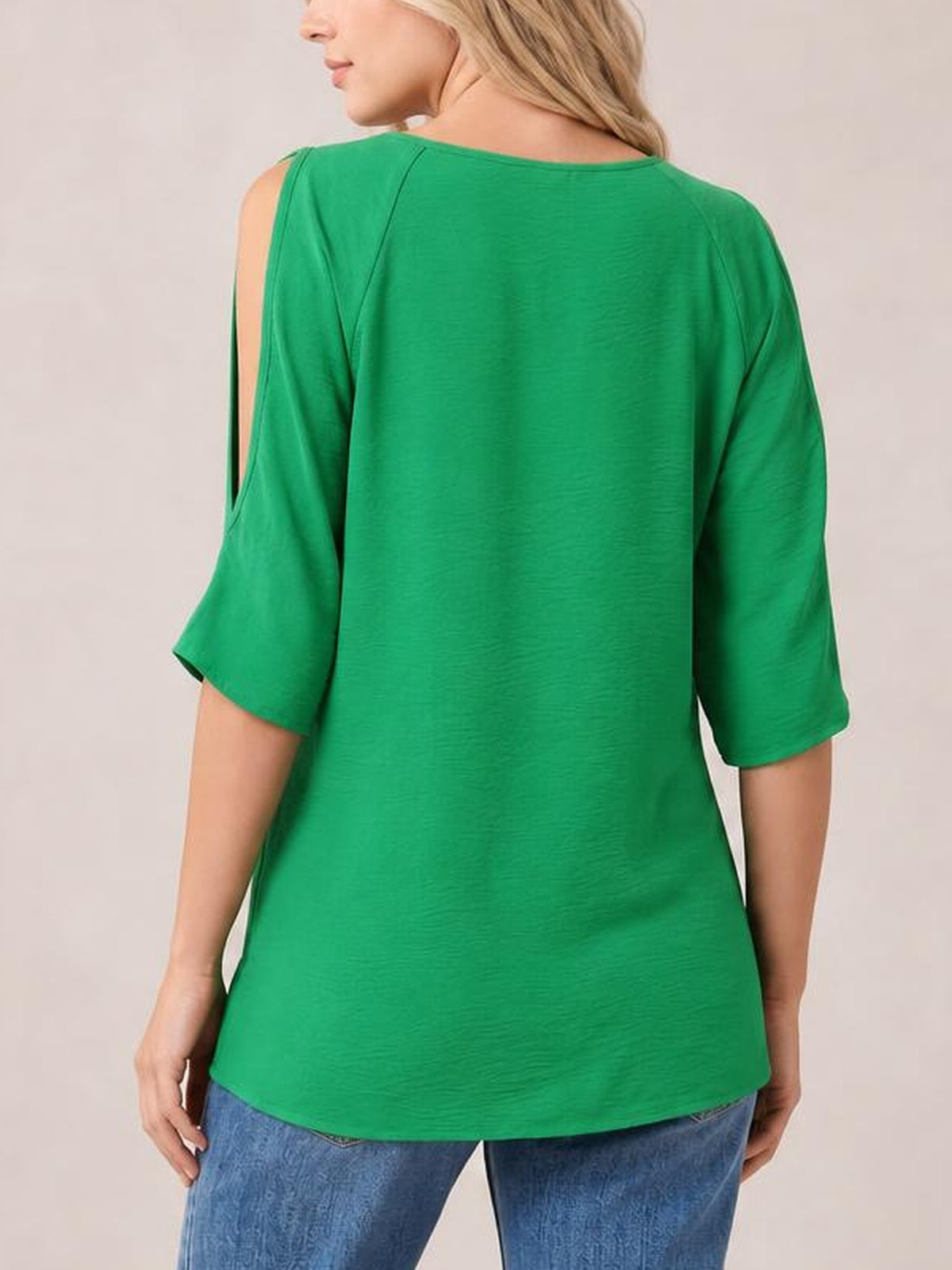 A model shows the back of a green textured round neck top with cold-shoulder split sleeves, half-length sleeves, and a relaxed long silhouette.