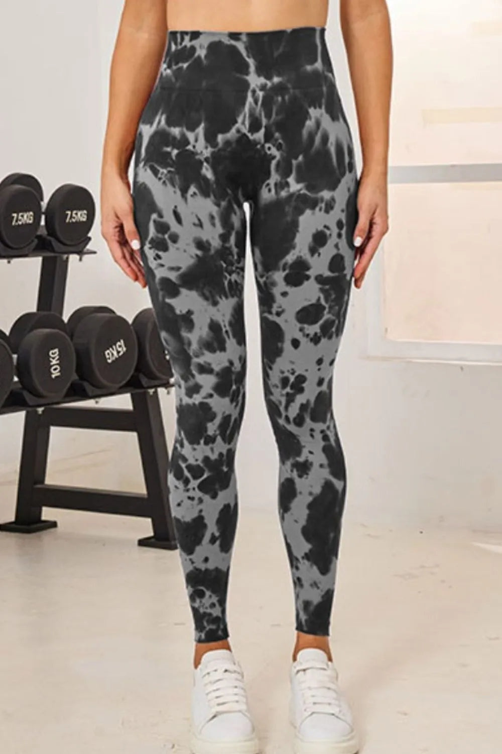 Model standing in black and gray tie-dye high-waist active leggings with a fitted full-length silhouette and slight stretch.