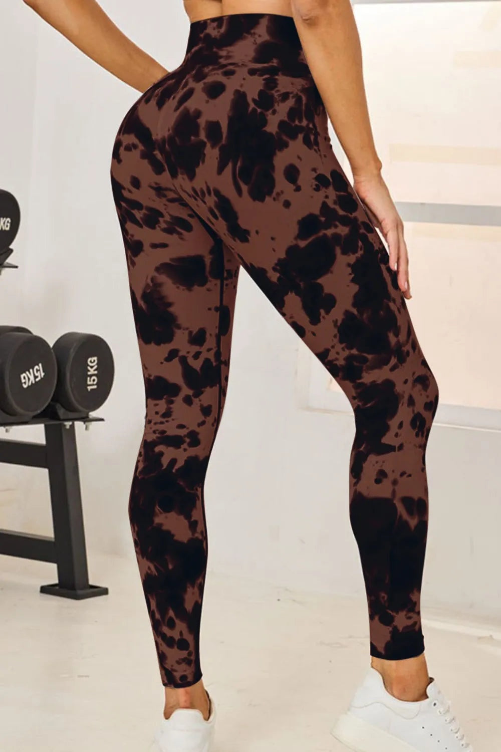 Model poses in high-waist, full-length tie-dye active leggings with a fitted silhouette, brown and black abstract pattern, and slight stretch.