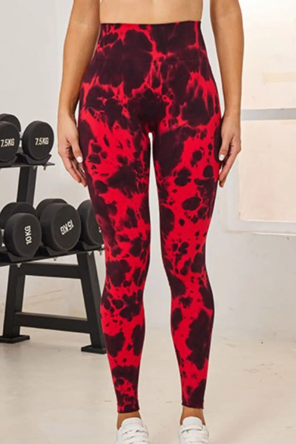 Model stands with hands at her sides wearing high-waist active leggings in a bold red and black tie-dye print with a fitted full-length silhouette.