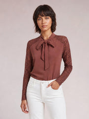 Model wearing a chic mauve tie-neck blouse with a bow, solid front, lace long sleeves and shoulders, and a regular straight silhouette.
