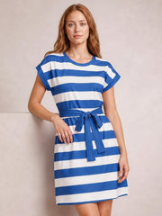 Model poses in a blue and white contrast striped short sleeve mini tee dress with a round neckline, straight silhouette, and tied waist.