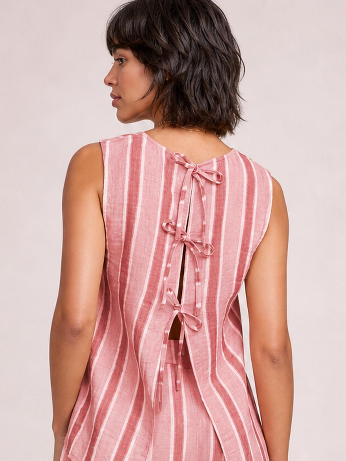 A model shown from behind wears a pink-and-white striped sleeveless top with multiple tie closures, an open-back detail, and a relaxed silhouette.