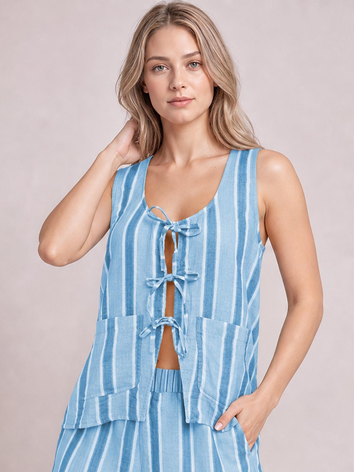 Model poses in a blue-and-white striped tied-front top and matching pants, featuring a relaxed silhouette, front bows, open center, and practical pockets.