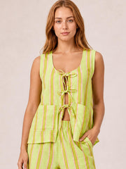 Model poses in a lime green and pink striped set with a sleeveless tied-front top, open waist details, relaxed pants, and practical pockets.