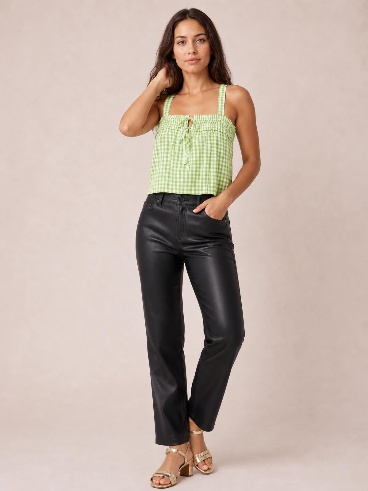 Model wears a light green textured gingham cami with a square neckline, wide straps, gathered trim, and a tied front in a relaxed pose.