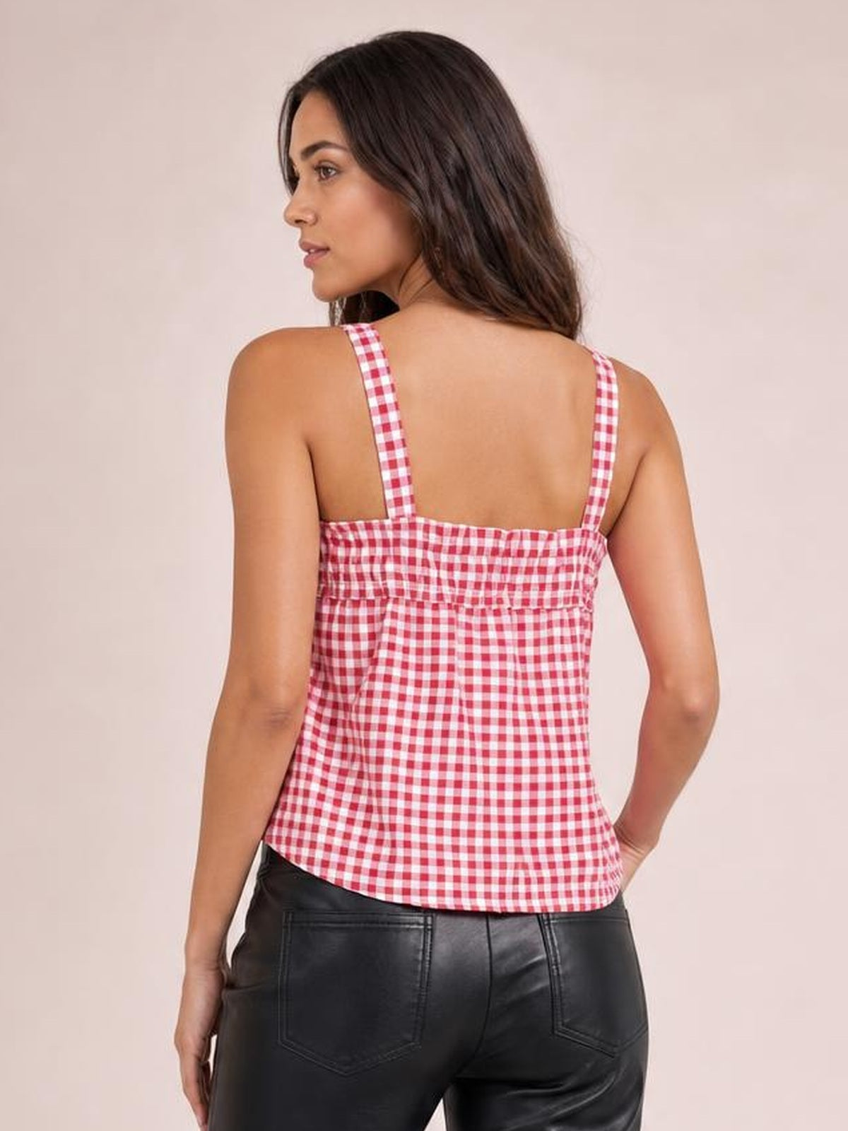 Model looking over her shoulder wears a red-and-white gingham textured cami with slim straps, a square back neckline, and a relaxed straight silhouette.