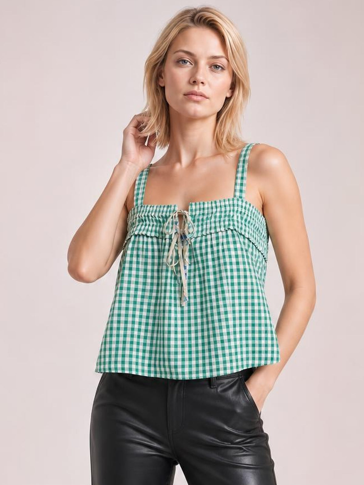 Model poses in a green-and-white textured cami with square neckline, slim straps, tied front detail, and a relaxed slightly flared silhouette.