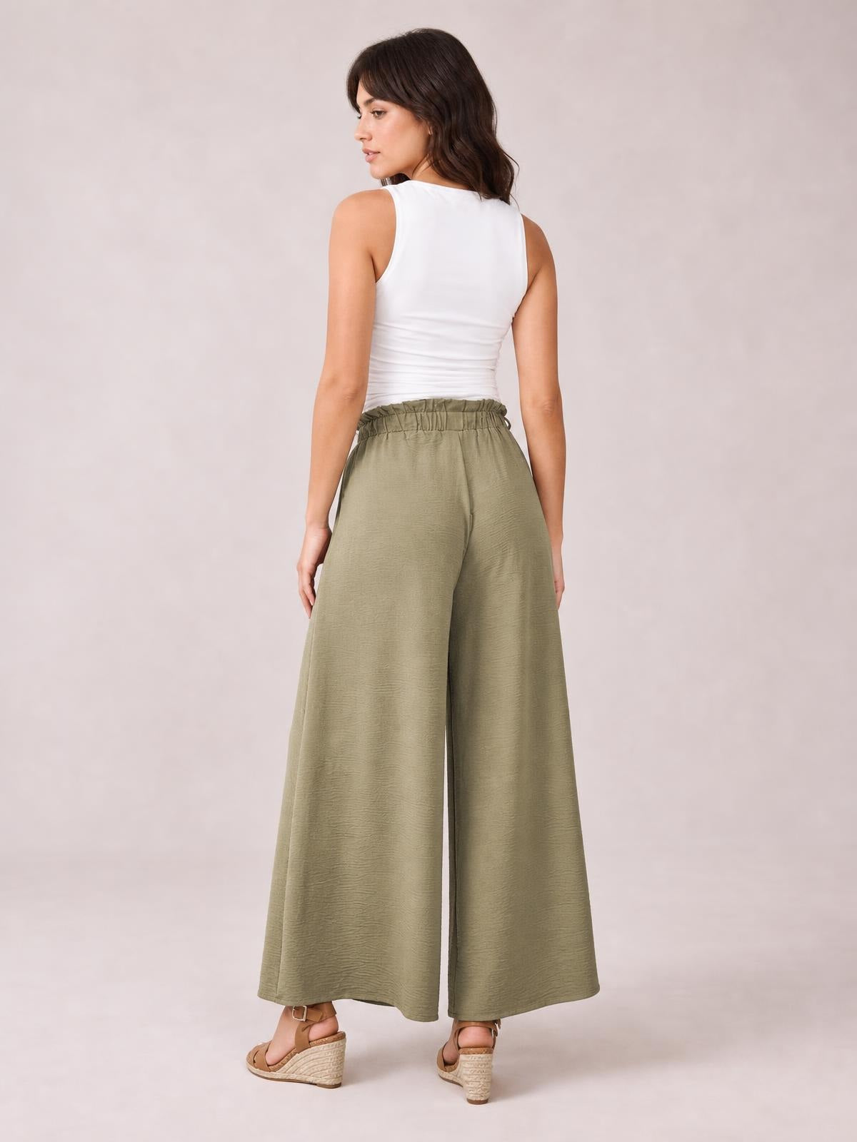A model looks over her shoulder wearing olive-green tied slit wide-leg pants with a gathered waistband and fluid, ankle-length silhouette.