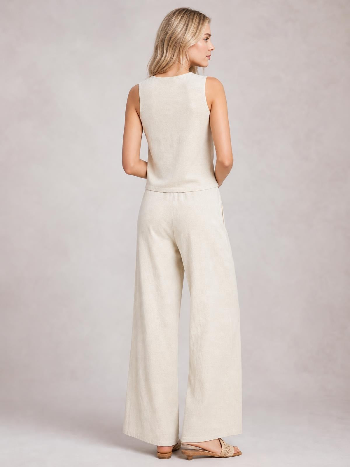 Model shown from behind in a cream sleeveless top and matching wide-leg pants, featuring a relaxed silhouette, clean construction, and drawstring waist.