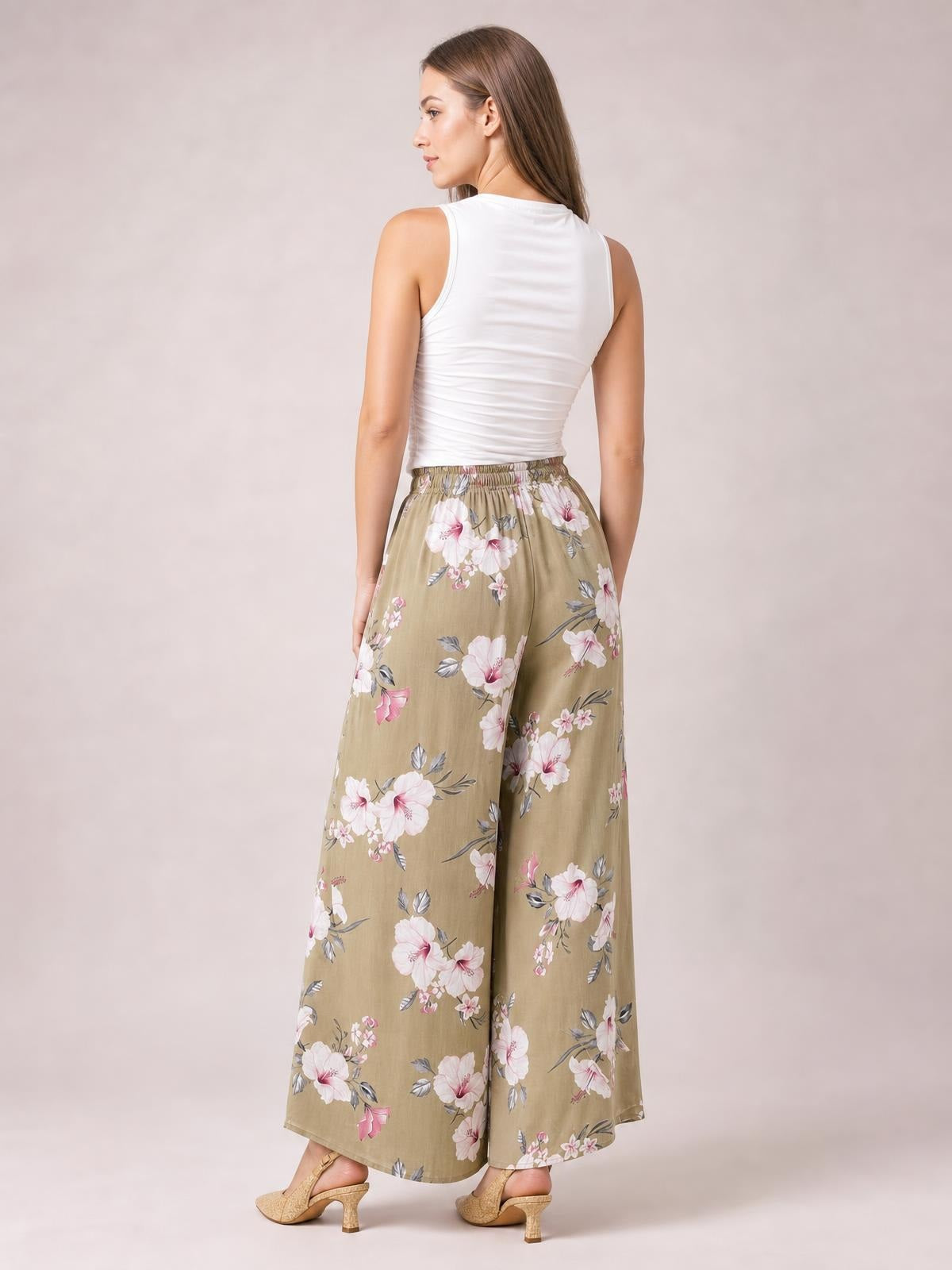 Model shown from behind wearing taupe floral wide-leg pants with a gathered waistband, relaxed flowing silhouette, and full-length hem.