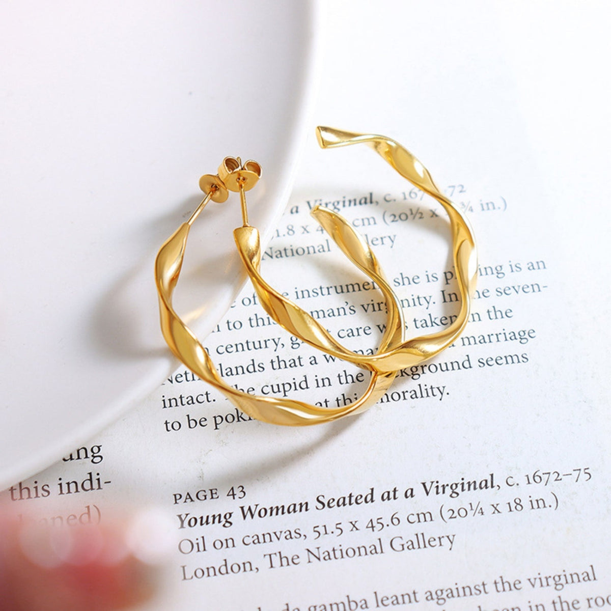 Gold-plated titanium steel C-hoop earrings feature a polished, gently twisted curved silhouette with slim post-back construction and a refined statement shape.