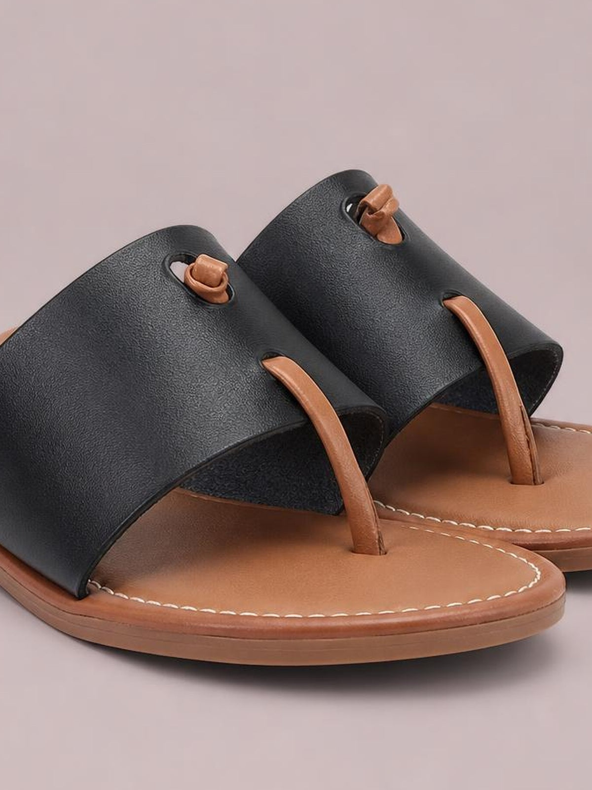 Black PU leather toe post flat sandals feature wide black straps, tan footbeds, brown thong posts, contrast stitching, and low rubber soles.