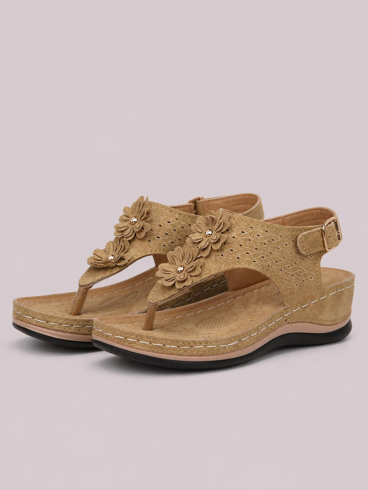 Tan toe post flower detail wedge sandals feature textured perforated uppers, ankle buckles, stitched platform soles, and comfortable mid-height wedges.