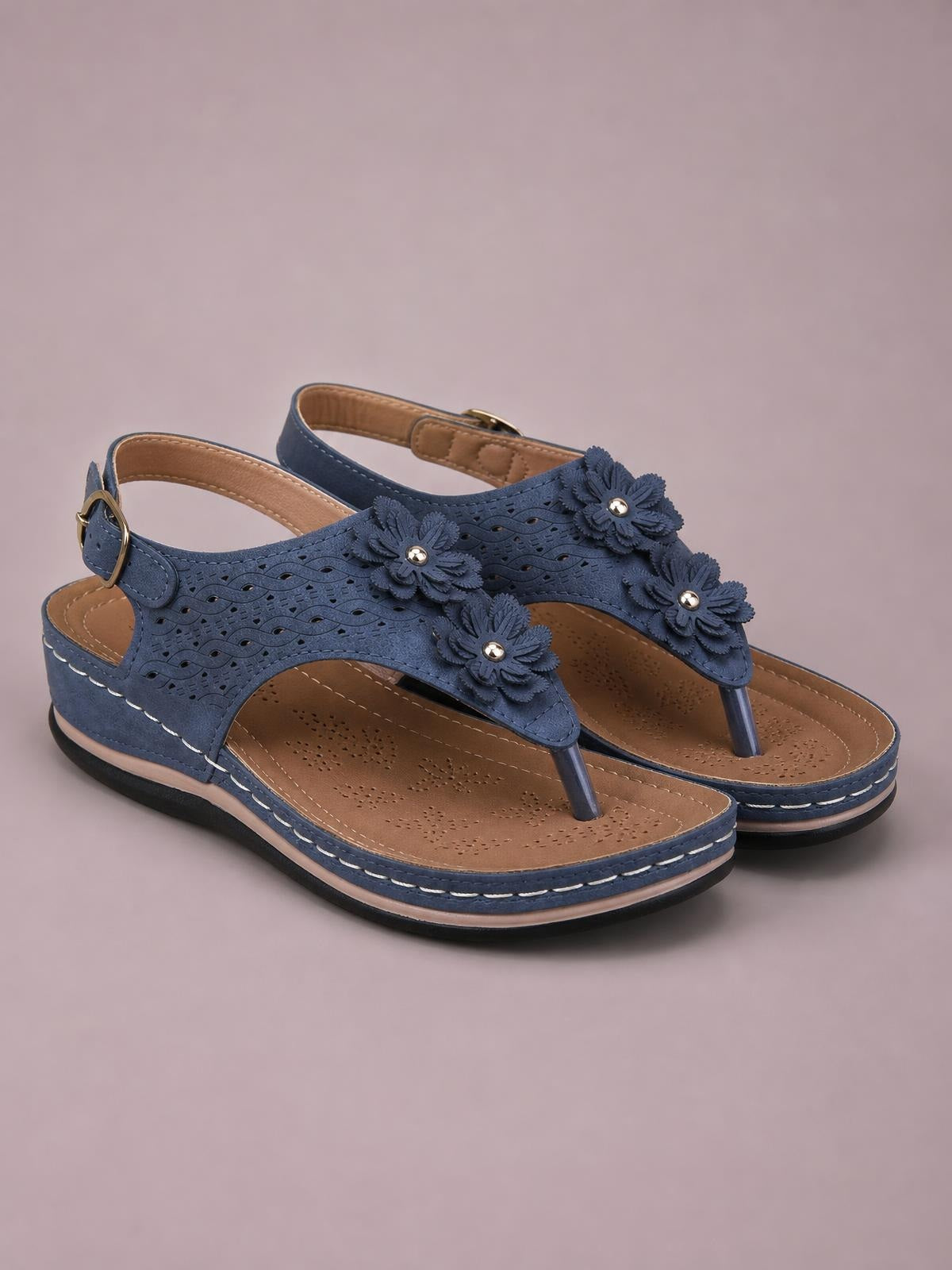 Navy blue toe post flower detail wedge sandals feature floral appliqués, cutout uppers, ankle buckles, cushioned footbeds, and mid-height wedge soles.