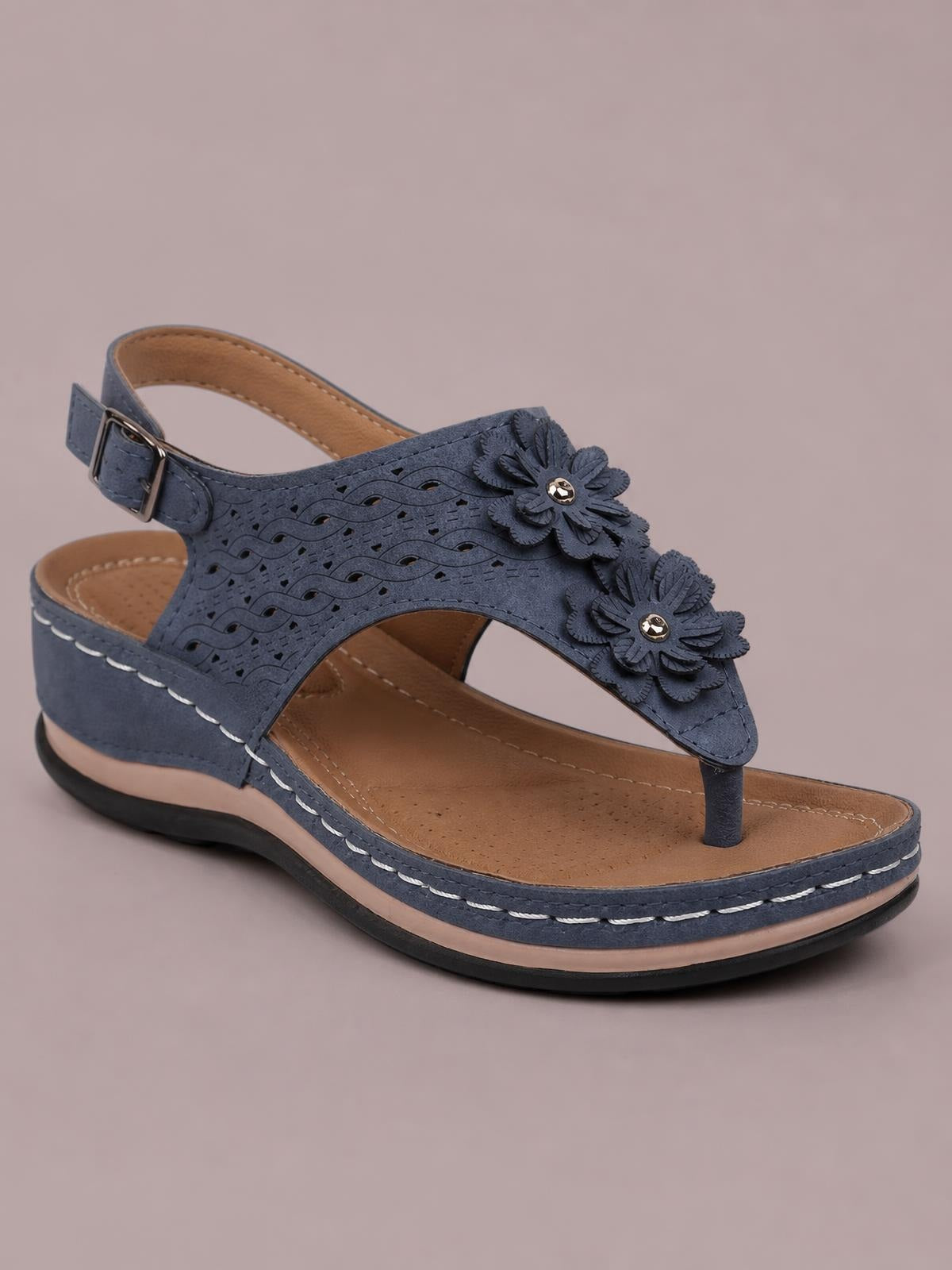 Navy blue toe post flower detail wedge sandal with perforated upper, layered floral accents, ankle buckle, open sides, and a stitched mid-height wedge sole.