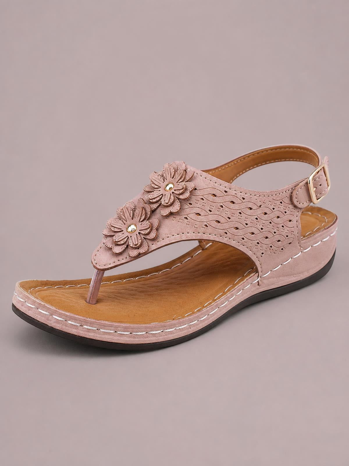 Pink toe post flower detail wedge sandals feature a perforated upper, layered floral accents, ankle buckle, stitched platform sole, and mid-height wedge heel.