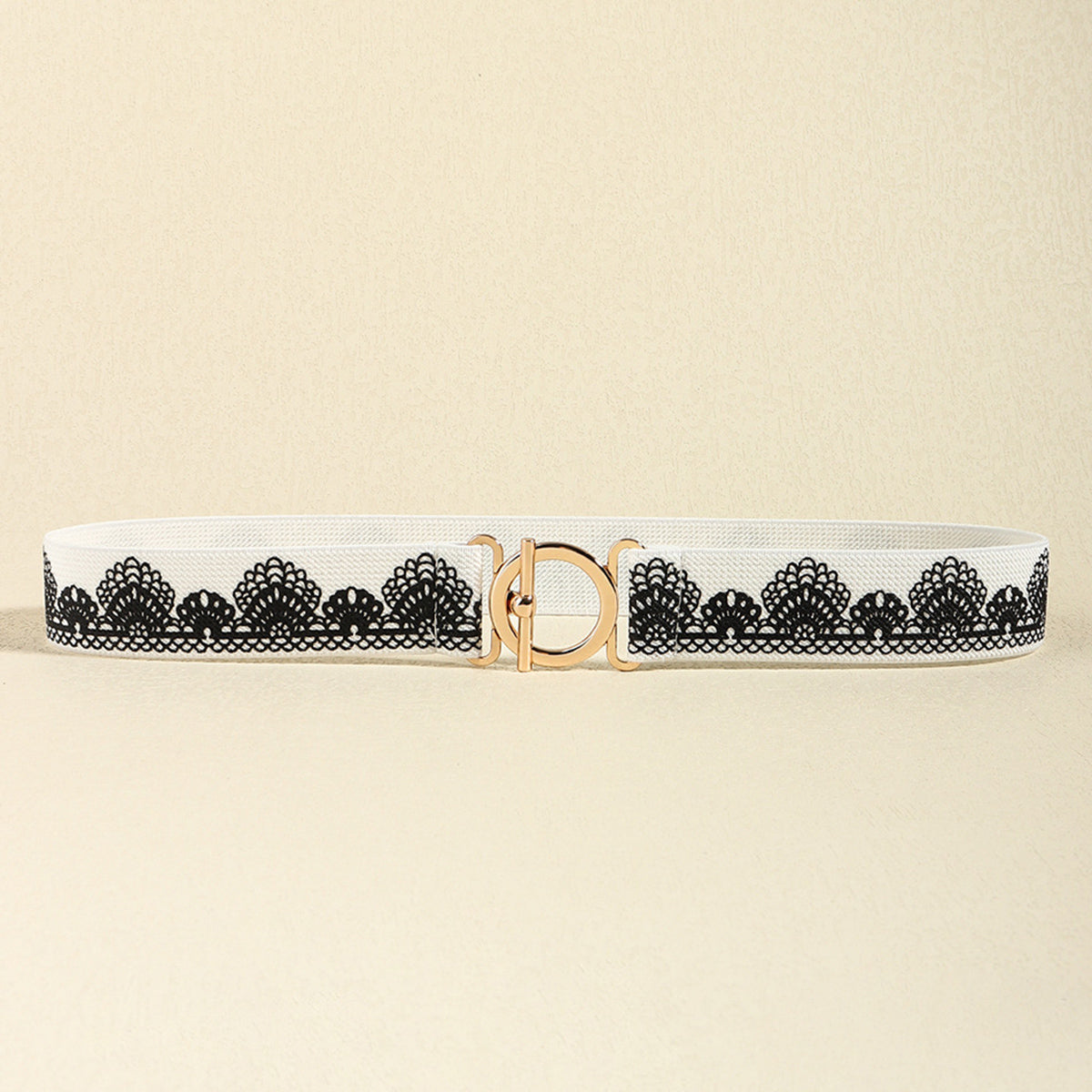 White elastic belt with black lace-inspired floral trim and a centered polished gold toggle clasp, featuring a slim 1.2-inch silhouette.