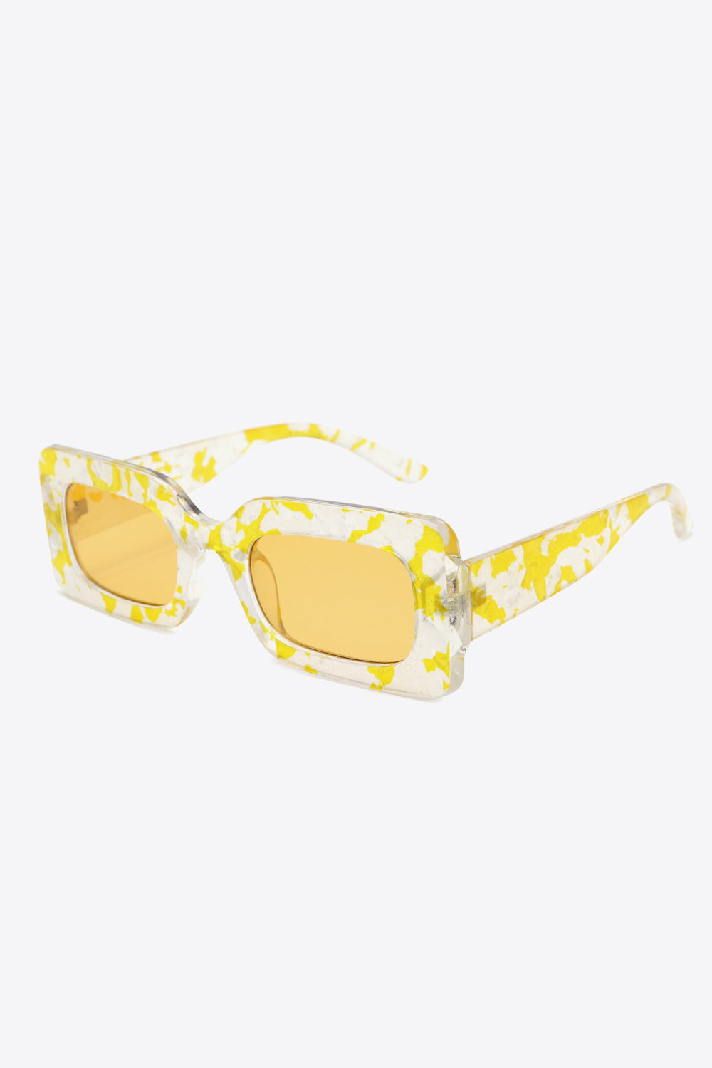 Rectangular polycarbonate sunglasses feature a clear frame with yellow marbled accents, amber lenses, and a structured three-quarter silhouette.