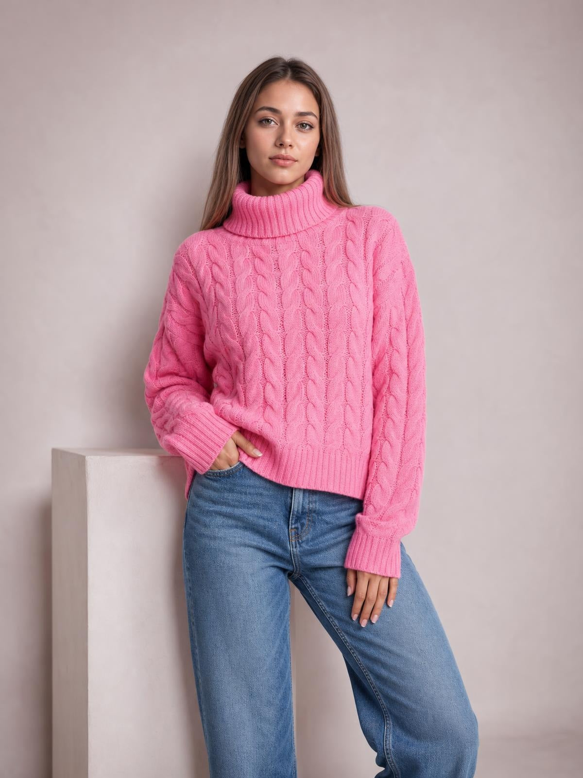 Model poses in a bright pink cable-knit sweater with a ribbed turtleneck, long sleeves, ribbed cuffs and hem, and a regular silhouette.