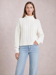 Model wearing a white cable-knit turtleneck sweater with long regular sleeves, ribbed cuffs and hem, and a relaxed regular-length silhouette.