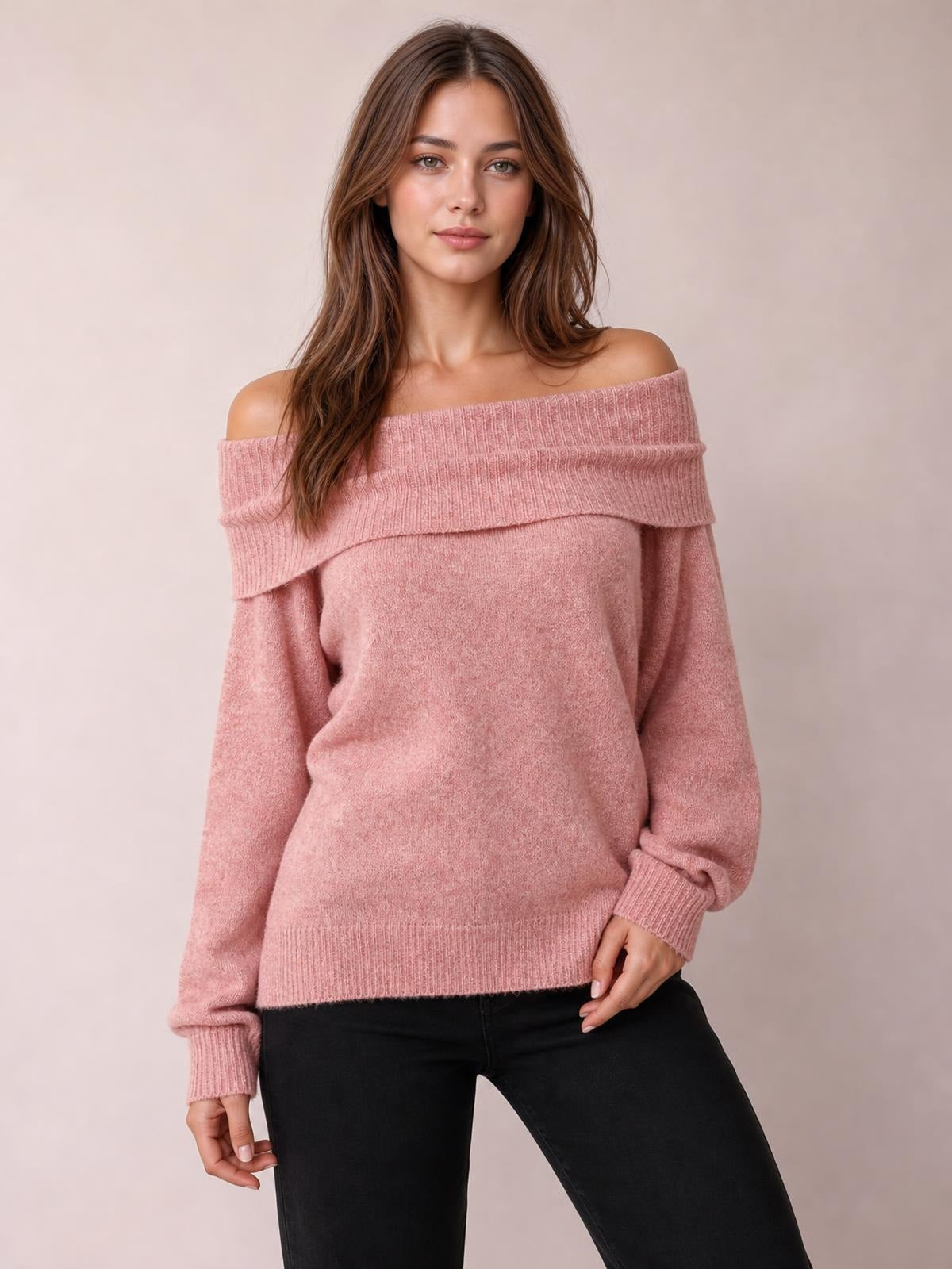 A model poses in a soft pink long-sleeve sweater with a wide folded off-shoulder neckline, relaxed silhouette, and ribbed cuffs and hem.