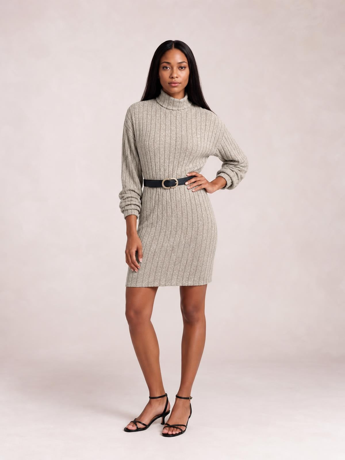 Model poses in a taupe ribbed knit turtleneck dress with long sleeves, a fitted mini silhouette, and vertical textured construction.