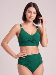 Model poses in a green twisted-front bikini set with ruched detailing, wide straps, and a high-waisted ruched bottom.