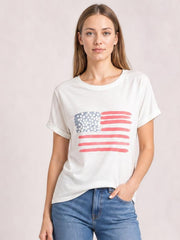 Model wearing a white US flag round neck short sleeve T-shirt with a relaxed silhouette, rolled sleeve cuffs, and red and blue flag graphic.