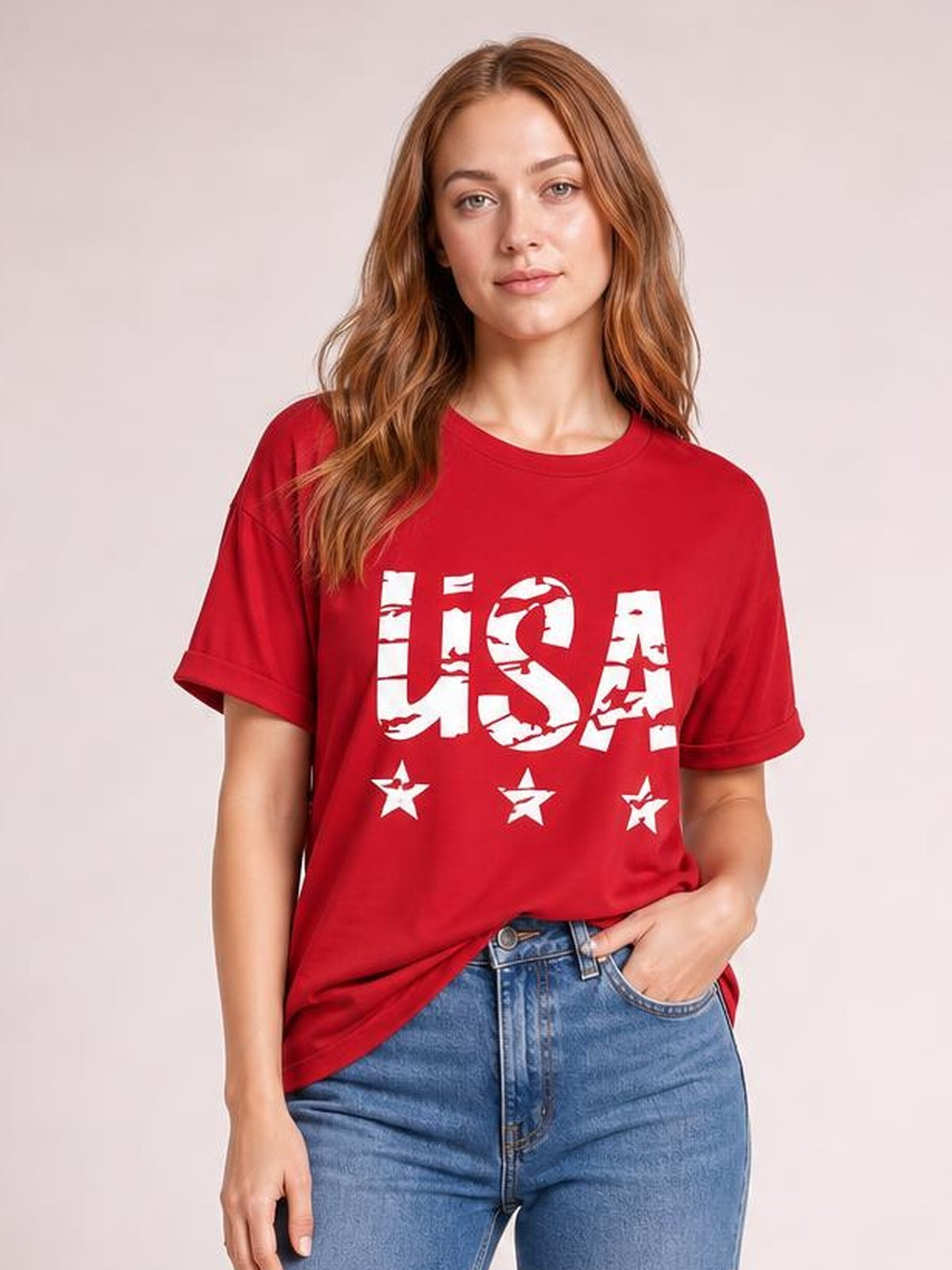 A model poses in a classic-fit red USA round-neck short-sleeve T-shirt with bold white lettering and star graphics, worn with blue jeans.