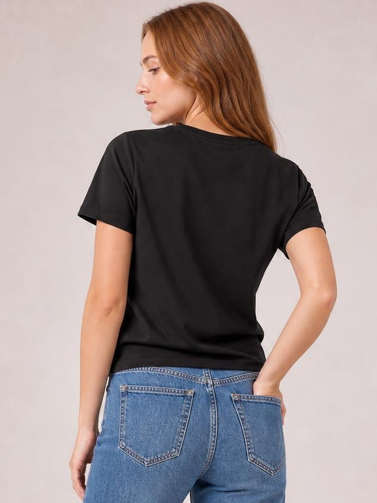 Model shown from behind in a black round-neck short-sleeve T-shirt with a relaxed basic silhouette, straight hem, and slight stretch, one hand on her hip.
