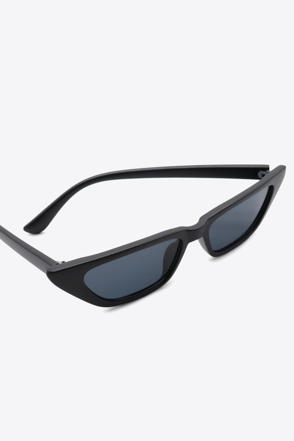Black UV400 cat-eye sunglasses feature an angular silhouette, tapered outer corners, dark lenses, and sleek polycarbonate frames with matching temples.