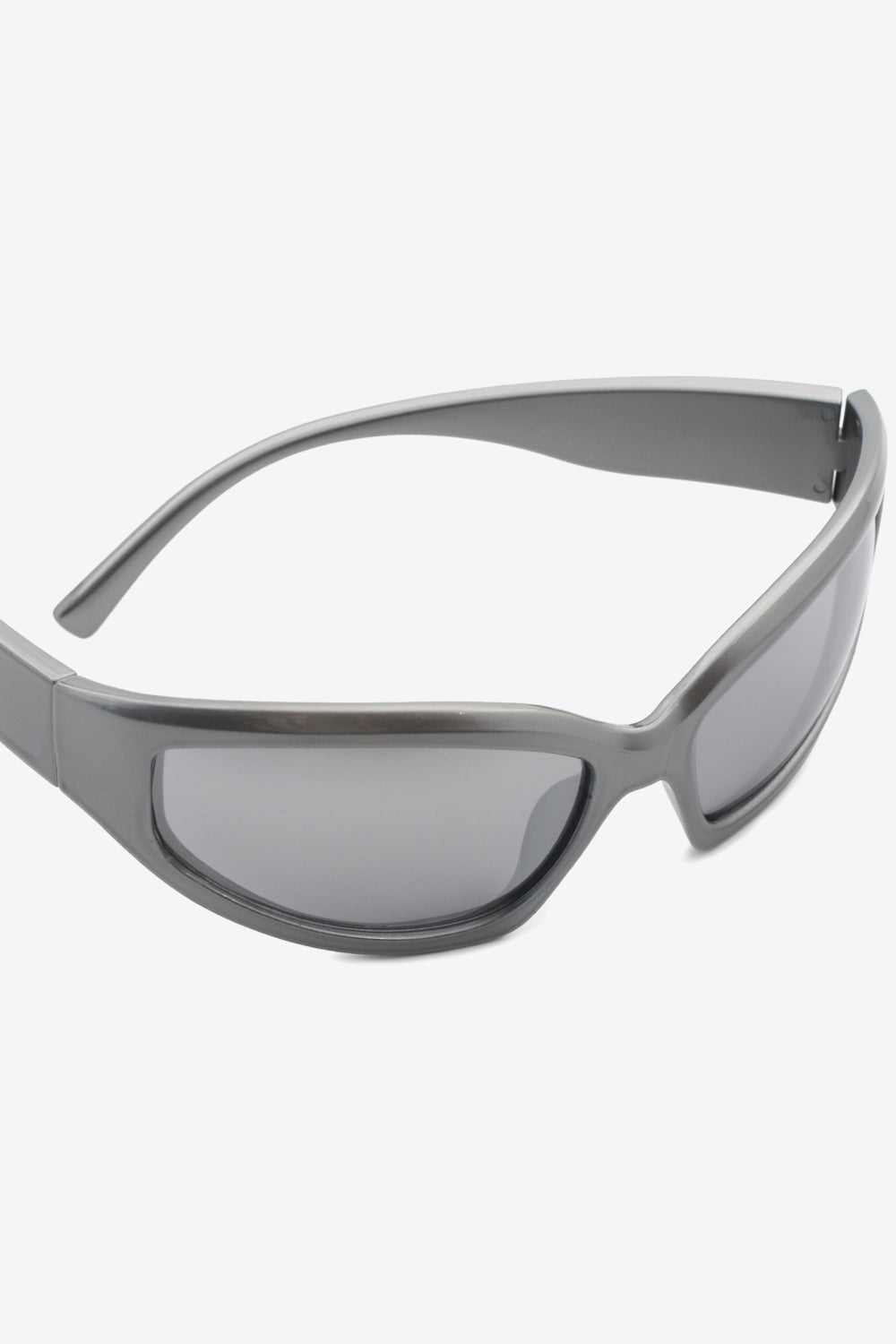 Mid-gray UV400 polycarbonate cat-eye sunglasses shown in close-up with softly curved frames, gray-tinted lenses, and streamlined temples.
