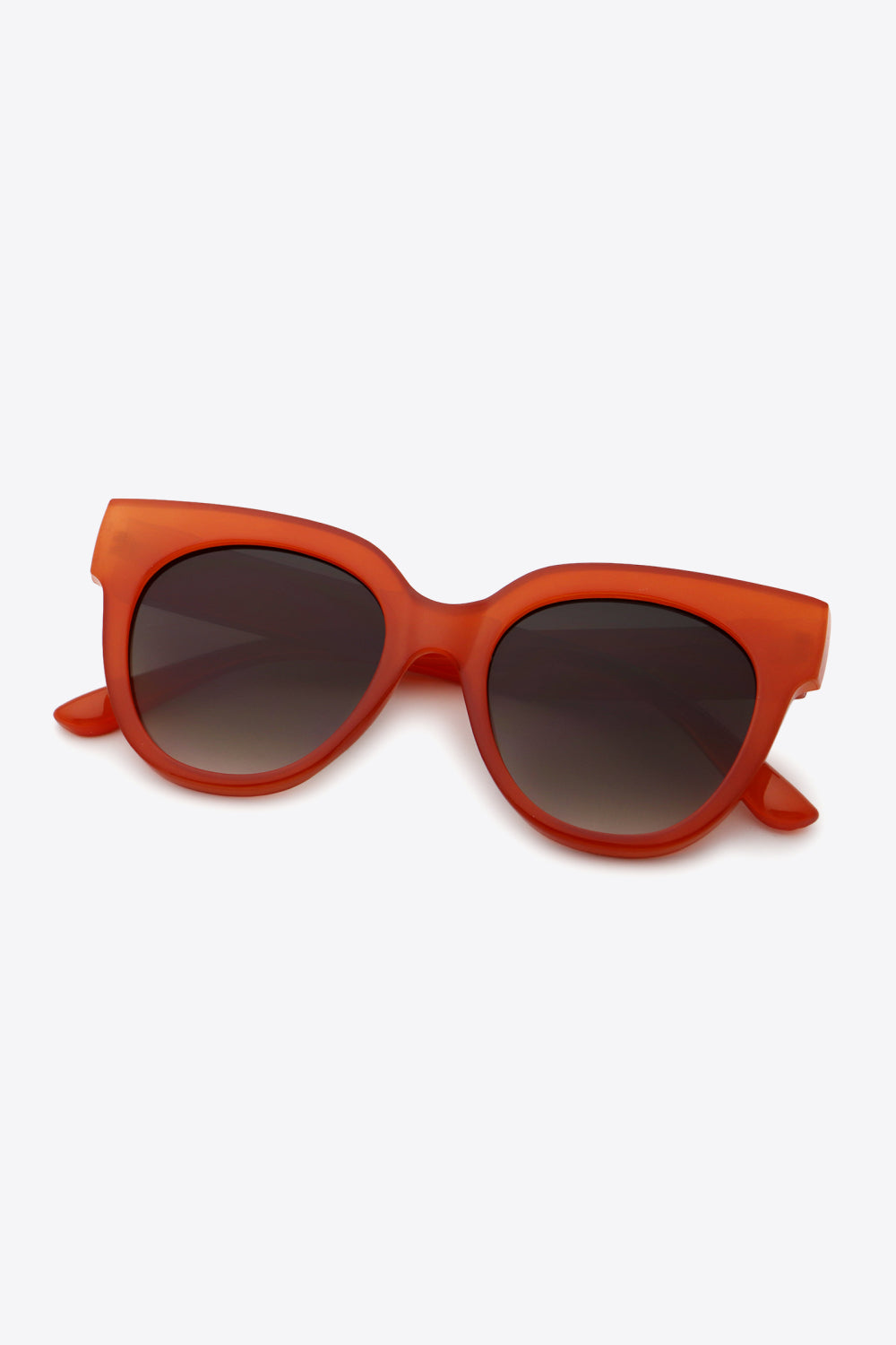 Deep red UV400 polycarbonate round sunglasses feature a bold curved frame, thick temples, and dark gradient lenses for a retro-inspired silhouette.