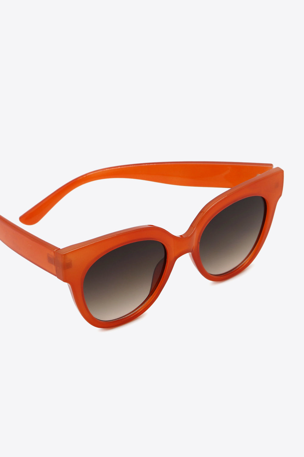 Deep red round sunglasses feature a bold polycarbonate frame, softly curved temples, and gradient-toned lenses for a polished retro-inspired look.