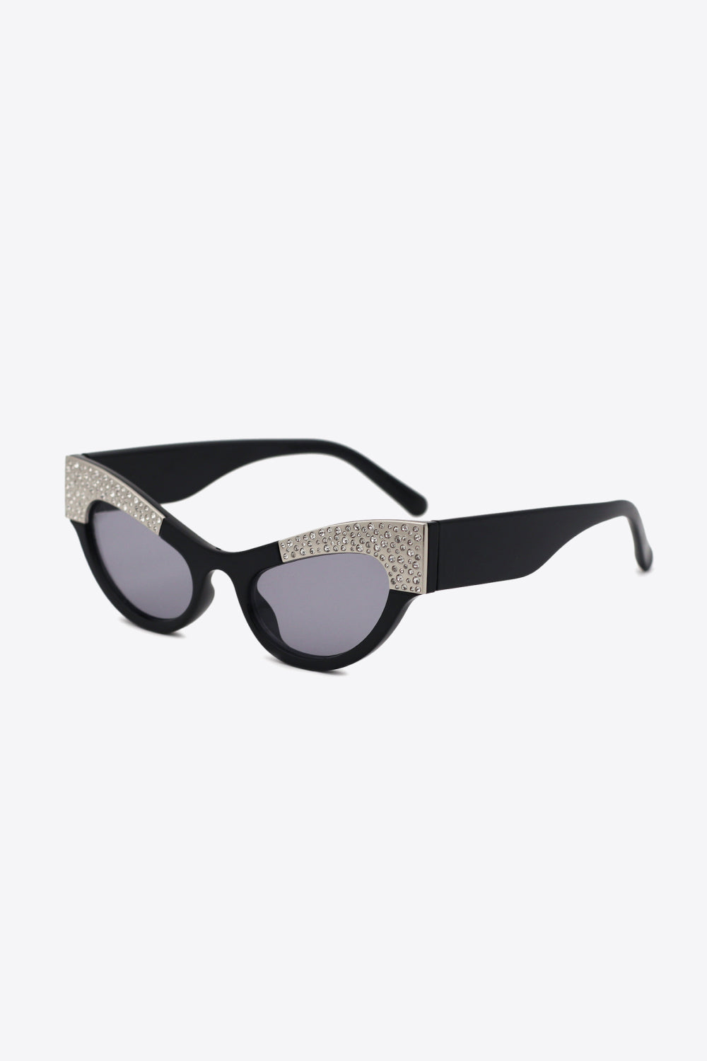 Black UV400 cat-eye sunglasses feature a sharply lifted silhouette, gray-tinted lenses, thick temples, and sparkling rhinestone trim across the upper frame.