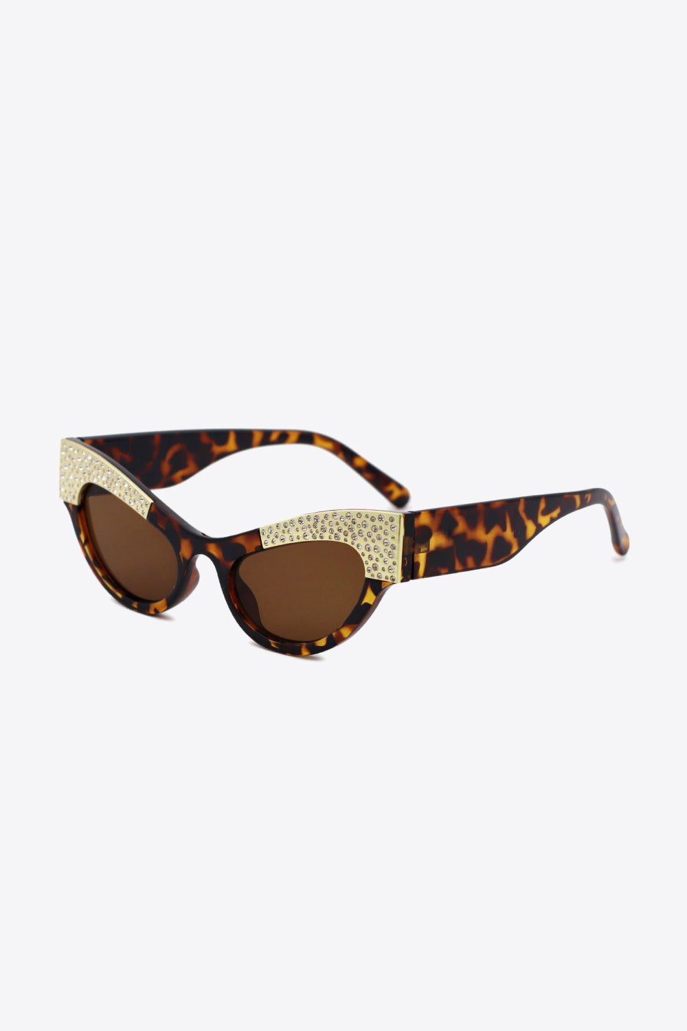 Tortoiseshell cat-eye sunglasses feature brown lenses and gold-tone rhinestone trim across the upper frame for a glamorous, sharply lifted silhouette.