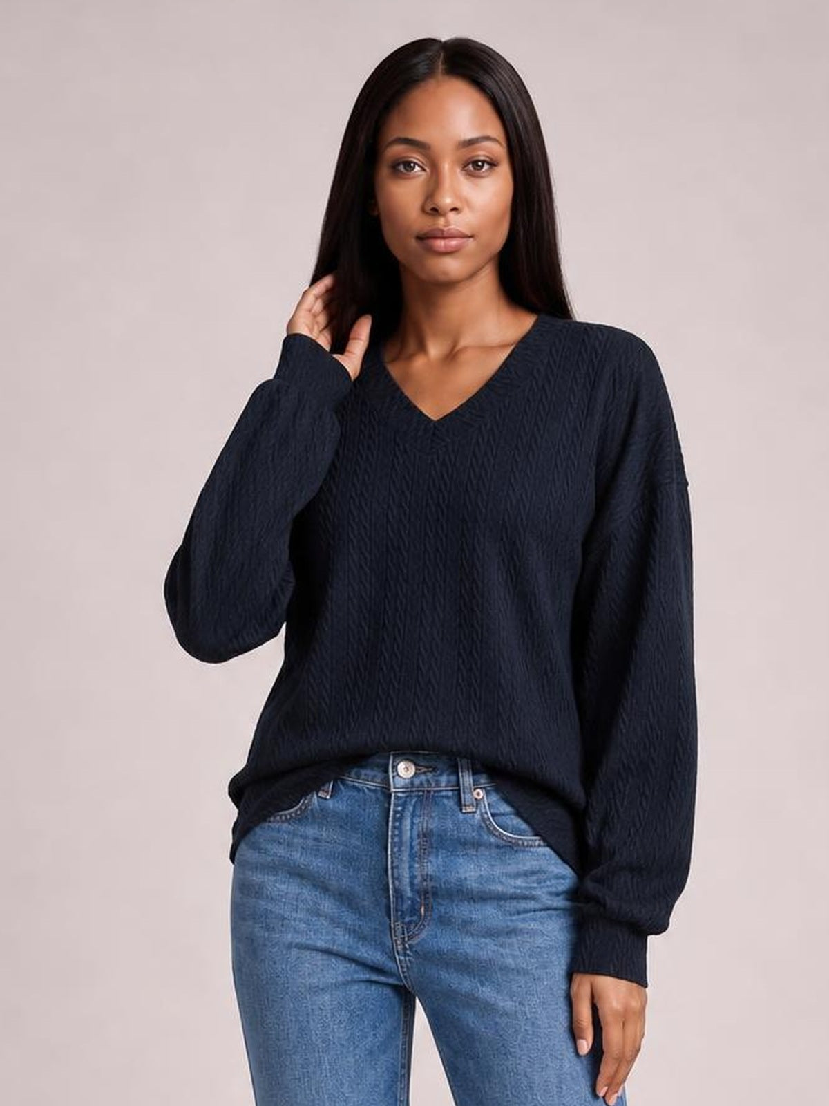 A model poses in a solid navy V-neck dropped-shoulder blouse with long sleeves, a relaxed long silhouette, and subtly textured construction.