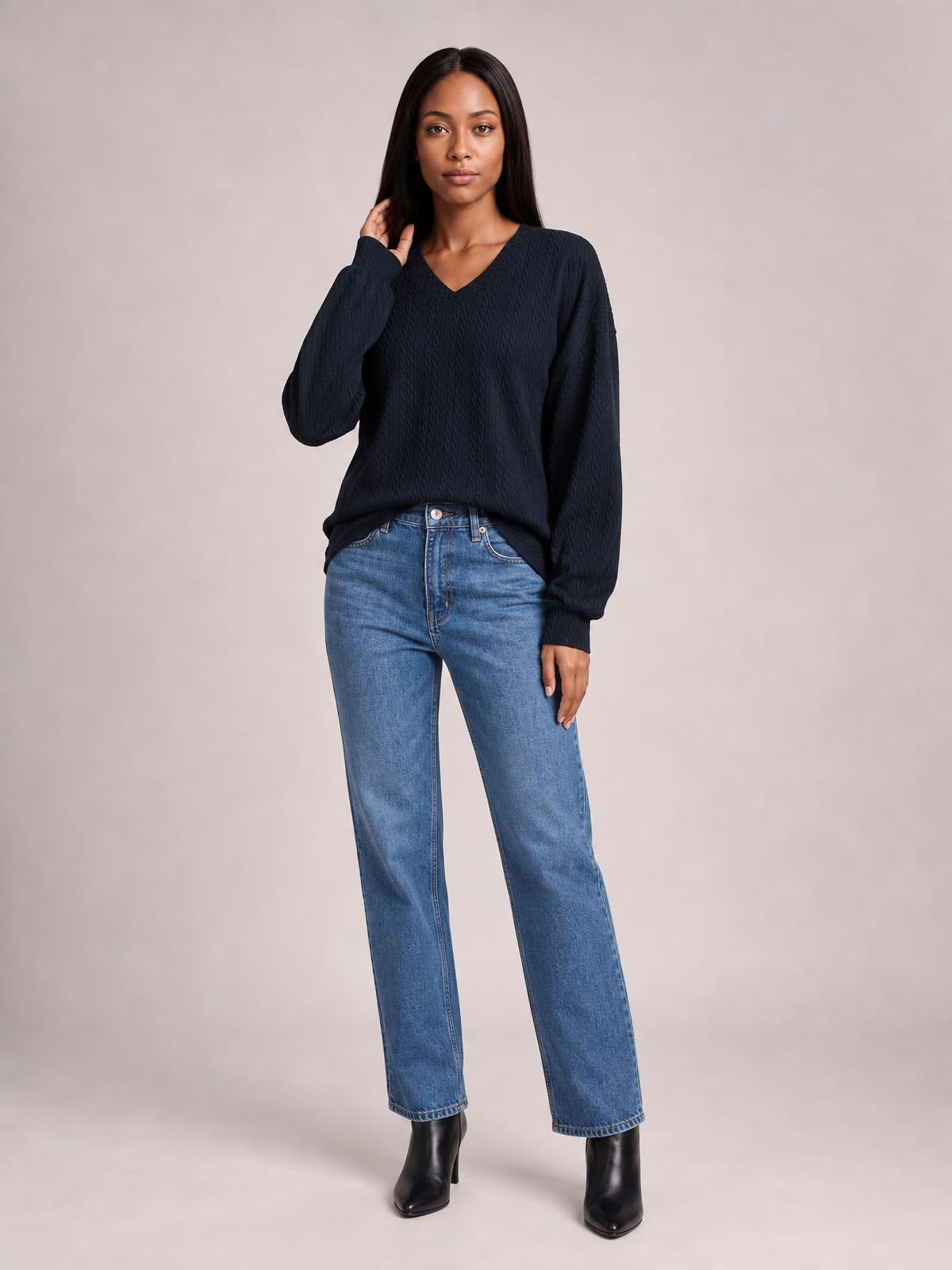 A model poses in a solid navy V-neck dropped-shoulder blouse with long sleeves, a relaxed long silhouette, and subtly textured fabric.