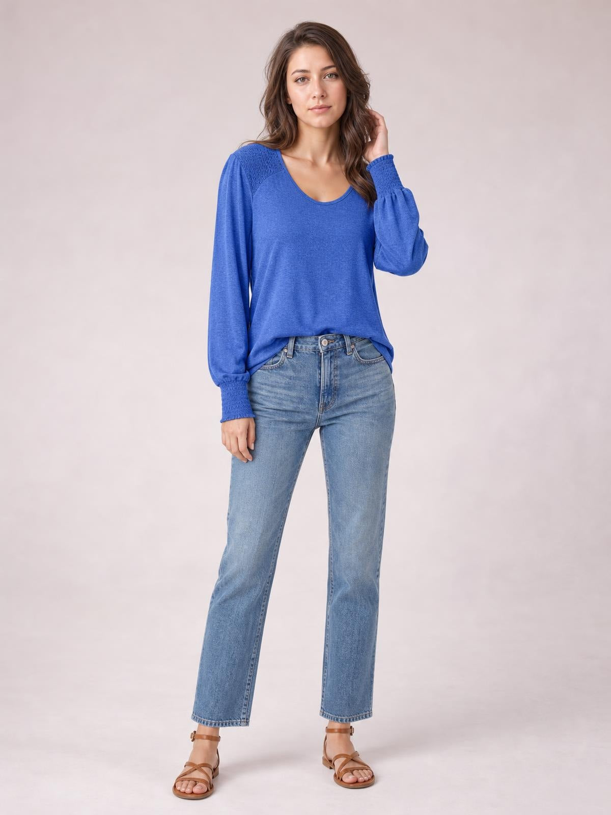 Model stands in a blue lantern-sleeve T-shirt with a rounded neckline, relaxed silhouette, gathered cuffs, and subtle shoulder detailing.