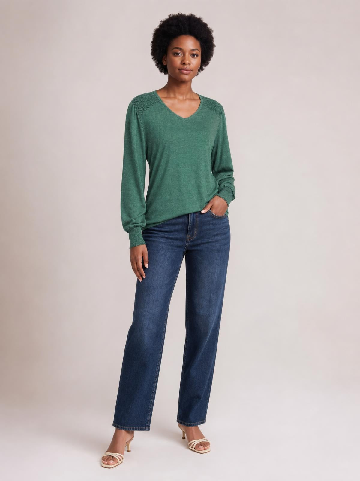 Model poses in a green V-neck T-shirt with gathered lantern sleeves, elastic cuffs, a relaxed silhouette, and subtle shoulder ruching.